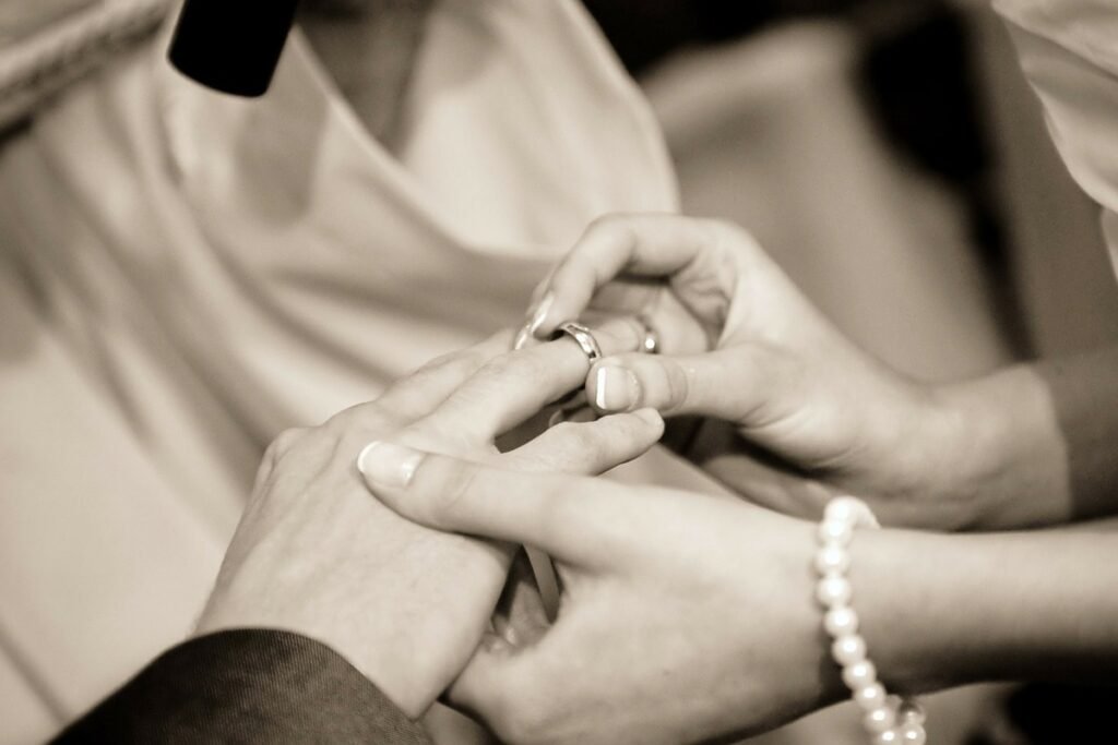 woman putting on a wedding ring on a man's finger