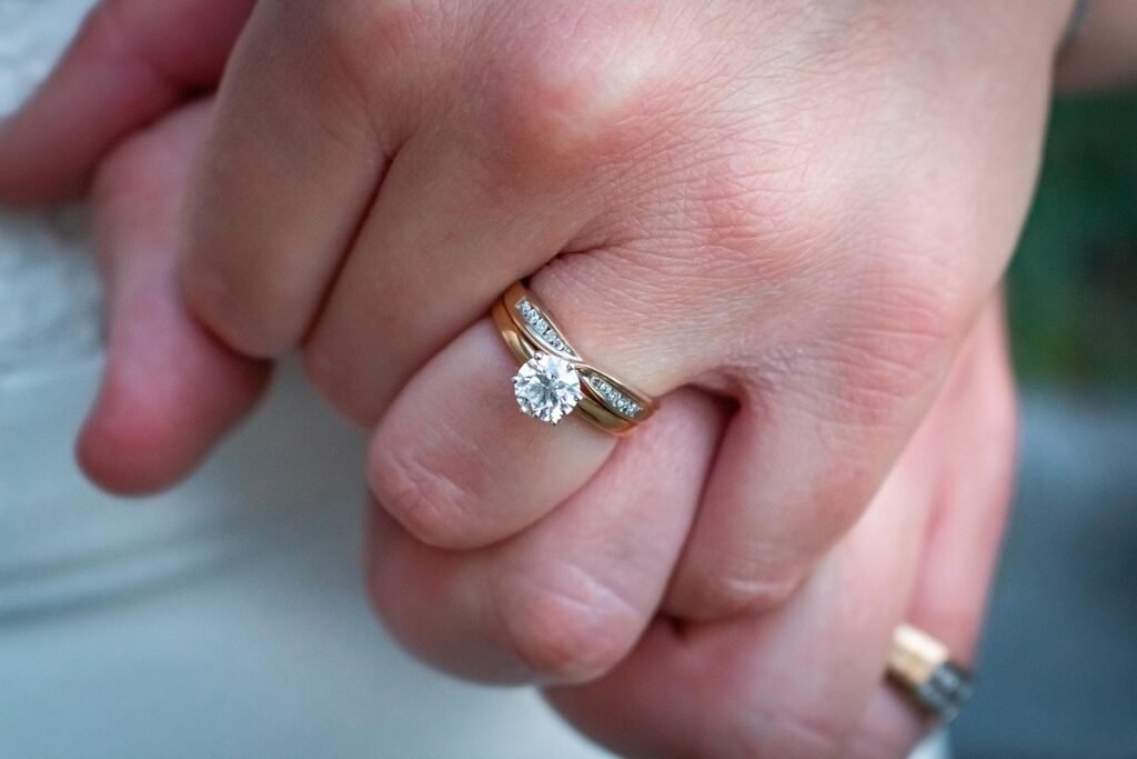 two hands wearing engagement rings