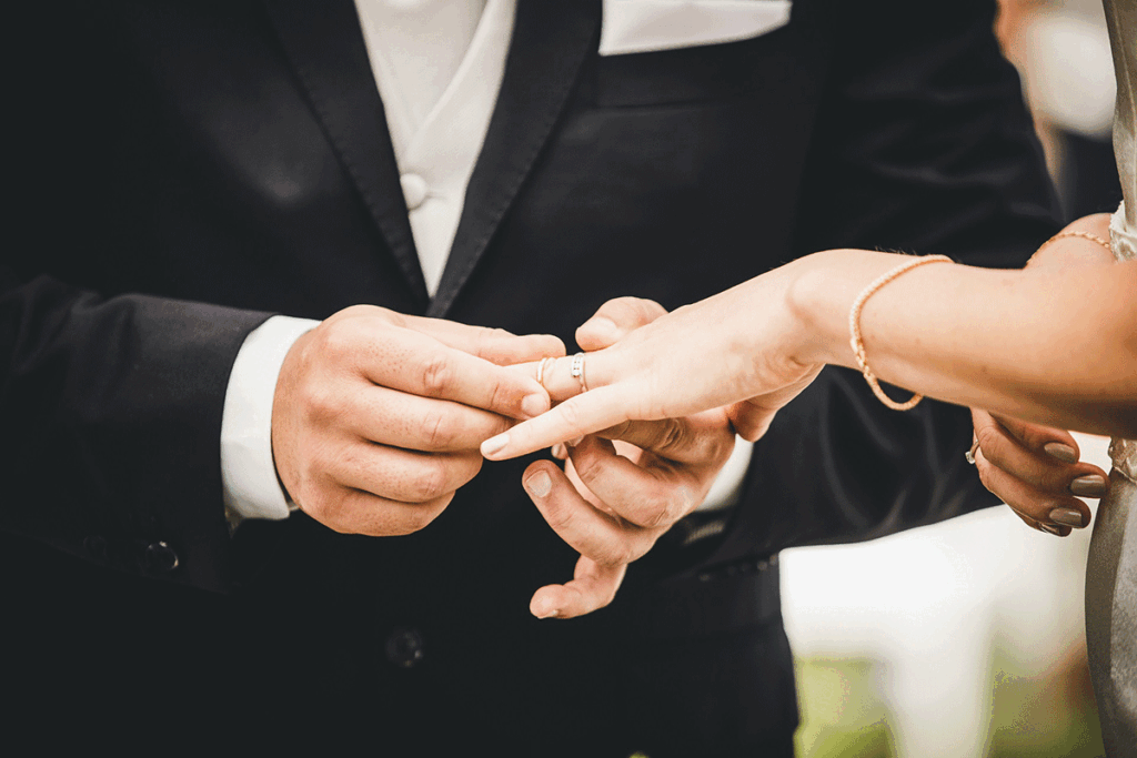 a man putting a wedding ring on a woman's finger
