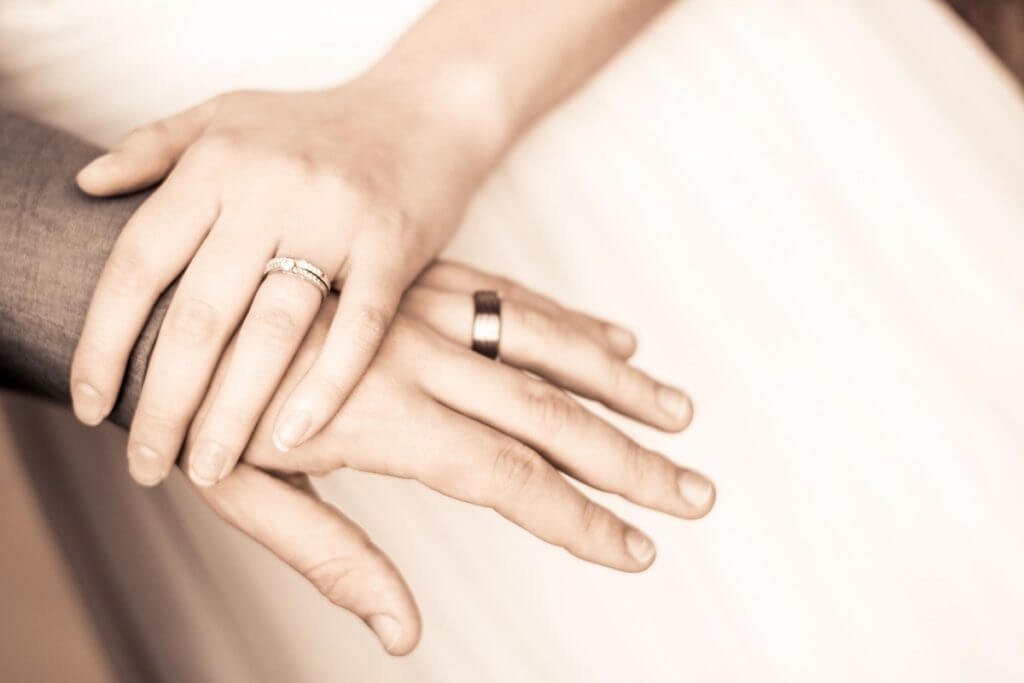 rings on a man and woman's fingers